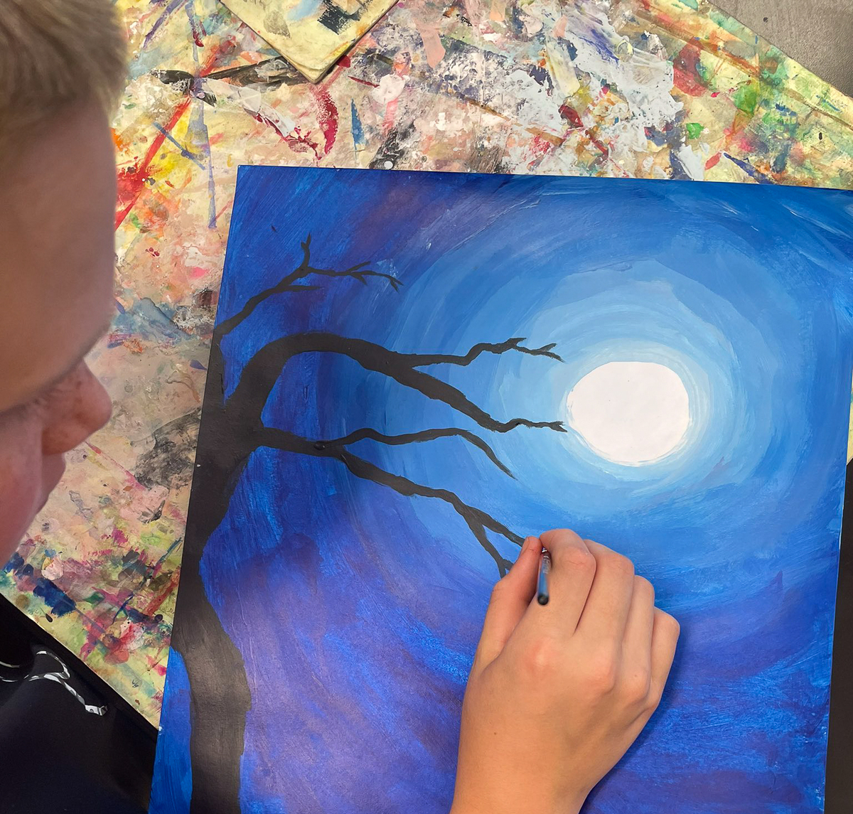 A Summit student paints a tree